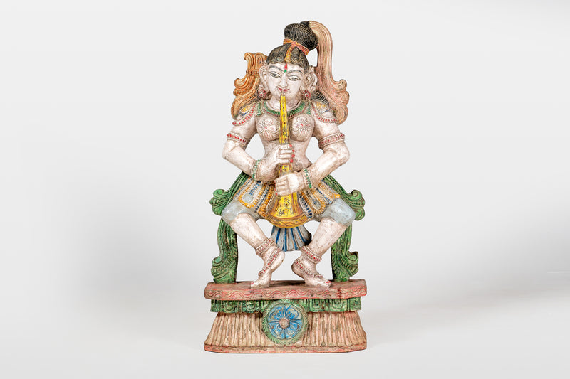 A Wooden Sculpture of a Musician Angel Playing Flute