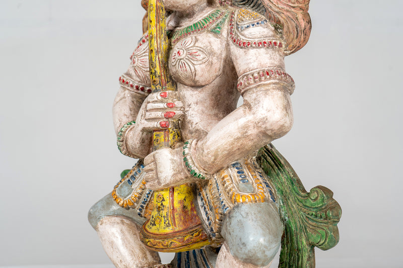 A Wooden Sculpture of a Musician Angel Playing Flute