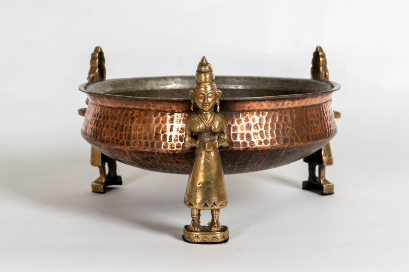 A Stippled Copper Cooking Vessel with Brass Figures