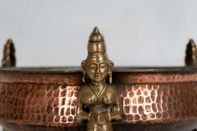 A Stippled Copper Cooking Vessel with Brass Figures