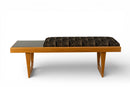 A Bench With a Cushioned Seat and Glass Table Top