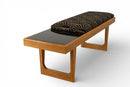 A Bench With a Cushioned Seat and Glass Table Top