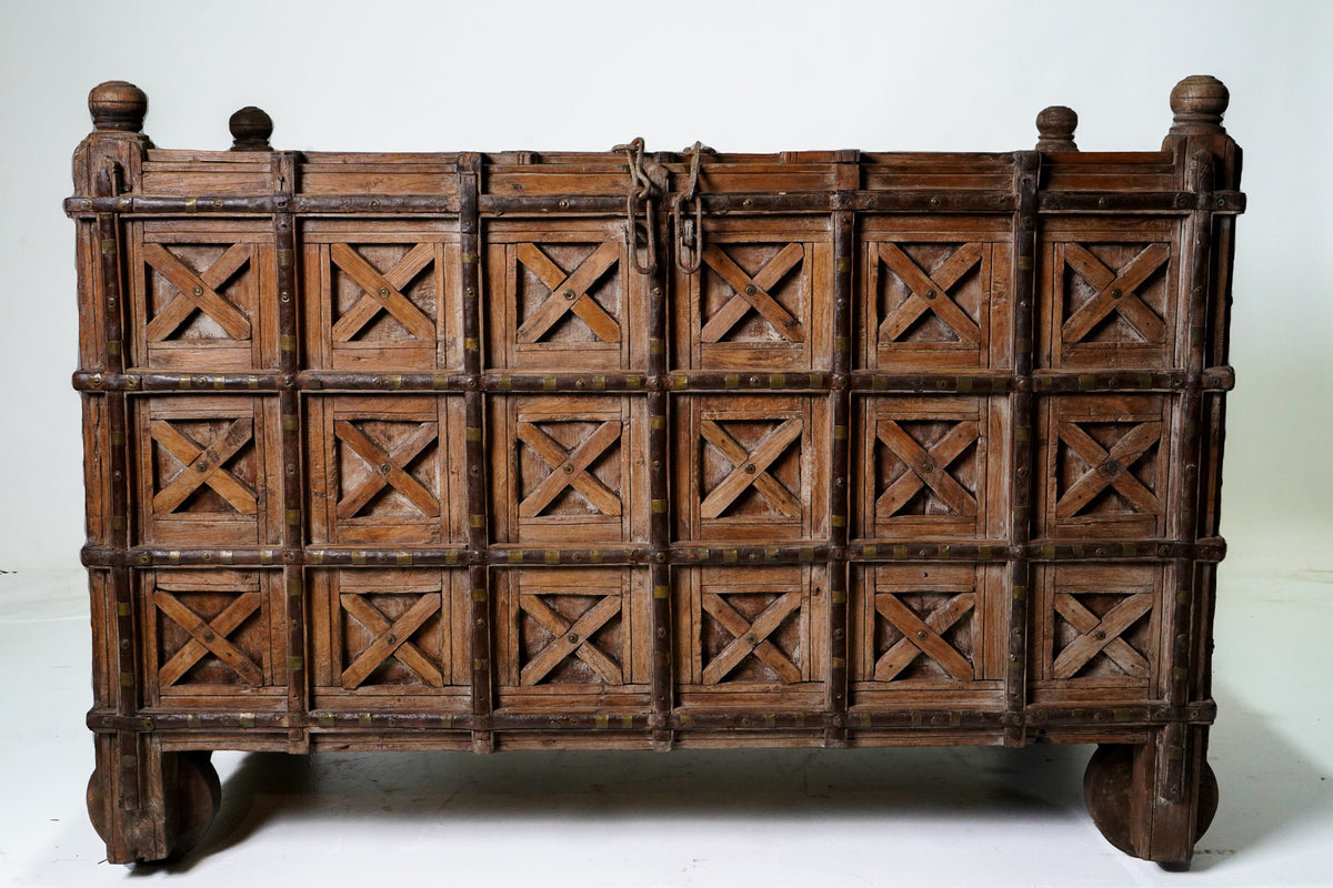 A Large Indian Storage Chest On Wheels
